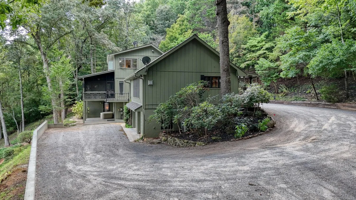 Driveway curving toward the main house with the attached garage visible ahead
