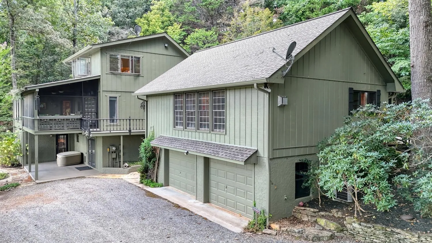 Main house exterior with attached two-car garage, viewed from the paved driveway